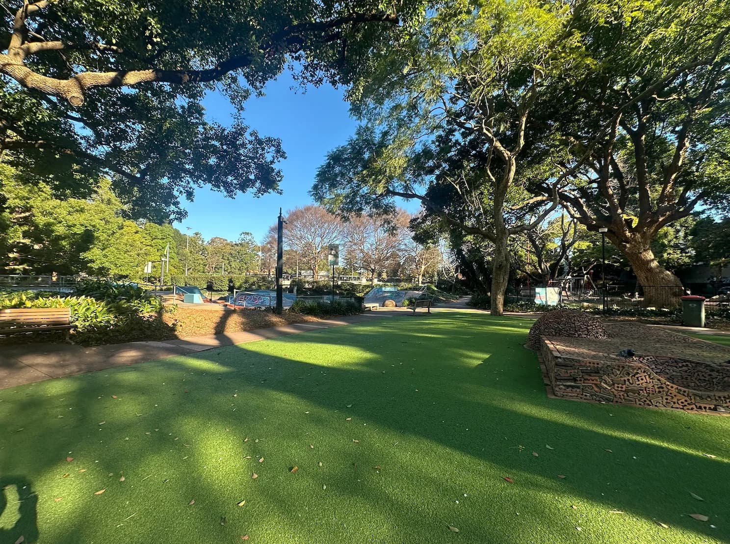 Lawn and stone garden edging beneath trees at Chatswood Park