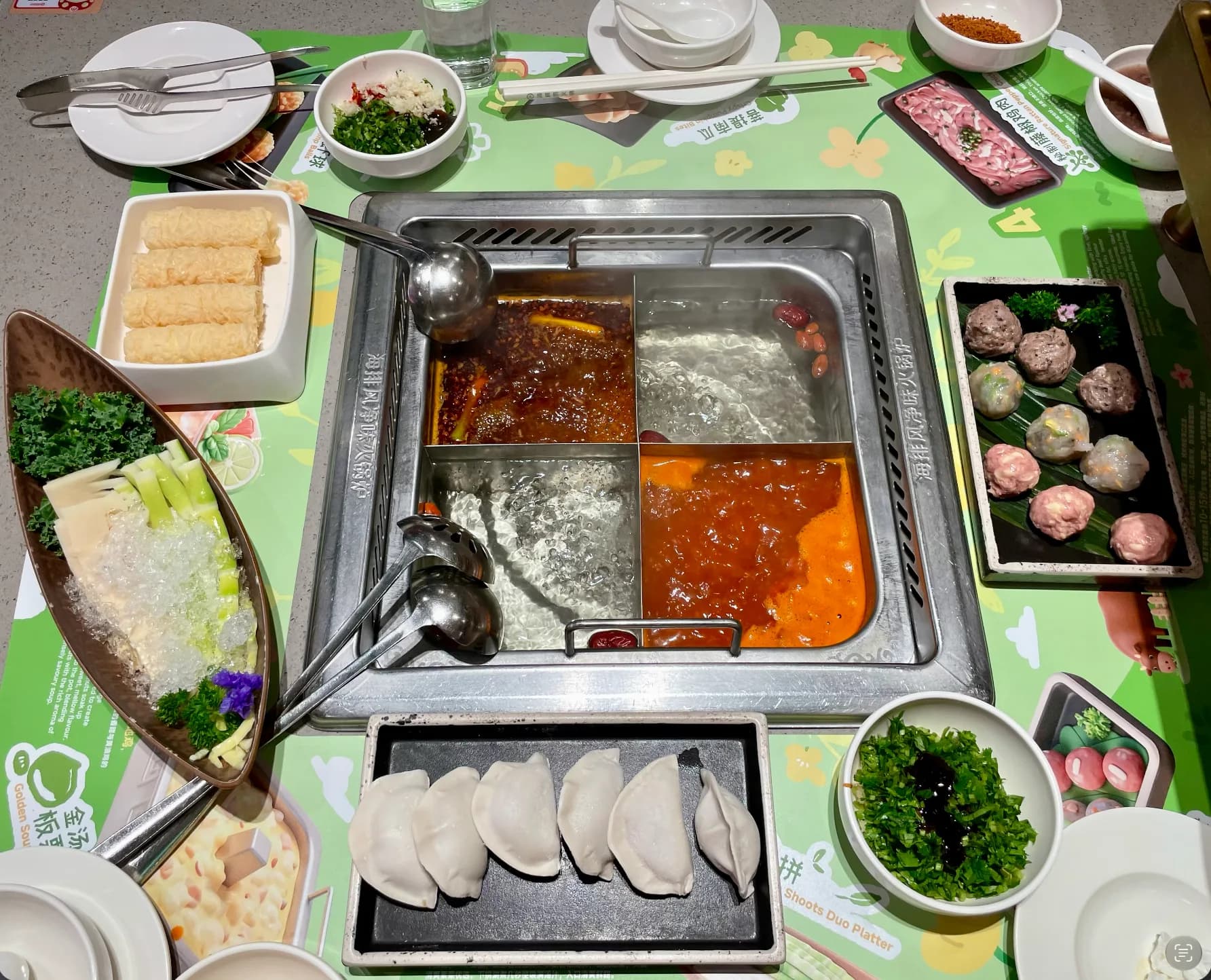 Four-compartment hot pot with ingredients ready to cook at Haidilao Chatswood