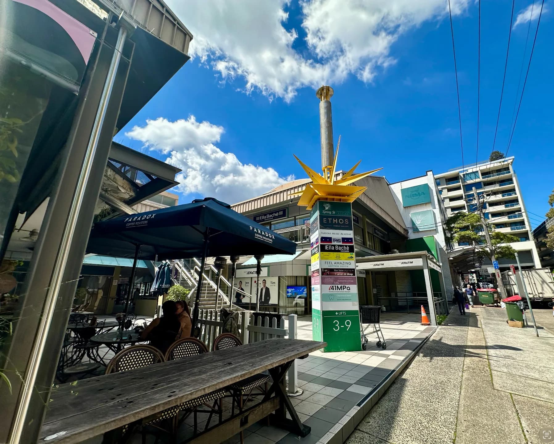 Outdoor seating and shopping-centre entrance on Spring Street, Chatswood